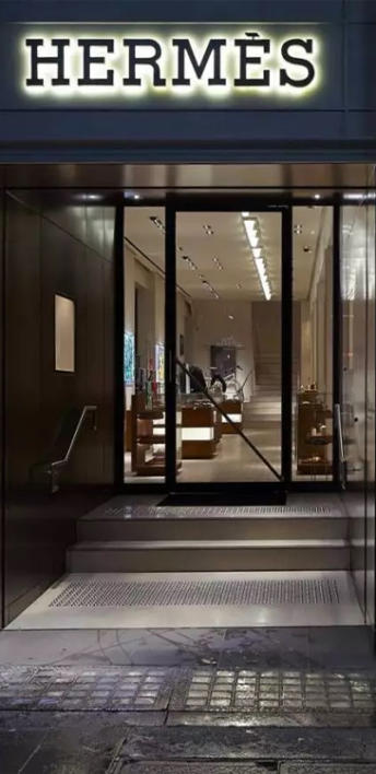 Front door of high end retail store selling bags.