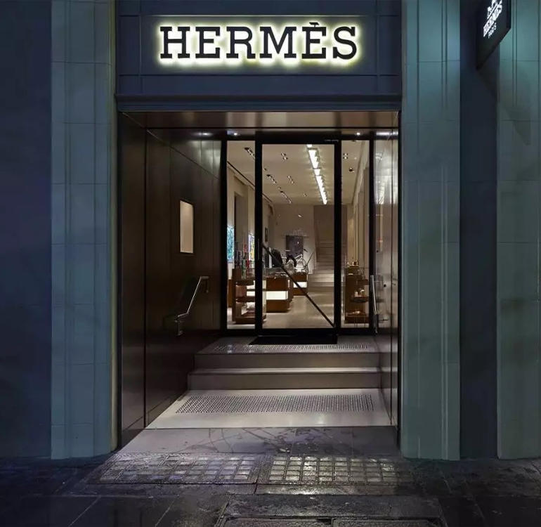Front door of high end retail store selling bags.